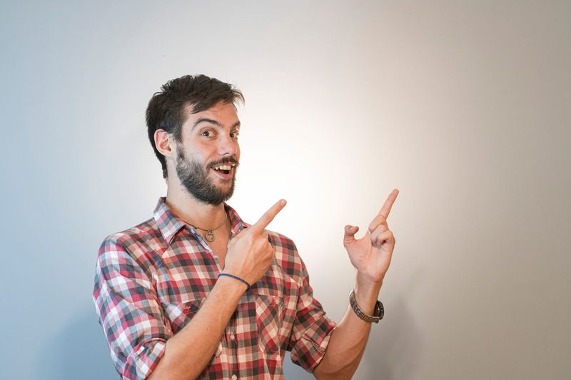 An ordinary photo of a person standing in front of a plain wall, before editing